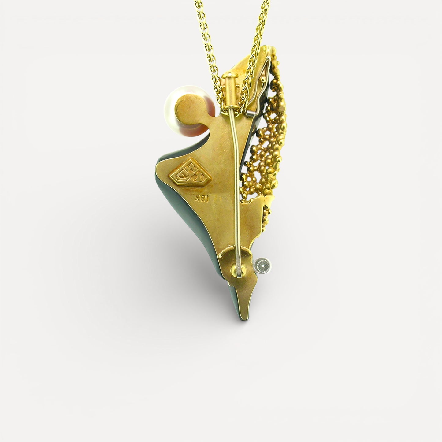 A black chalcedony carving by Steve Walters in an 18kt pendant and brooch with granulation, a diamond, and a pearl by ART Guyon for Cynthia Scott Jewelry.