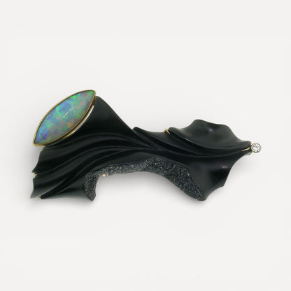 A black chalcedony carving by Steve Walters in an 18kt brooch and pendant with a diamond and Australian opal, made by ART Guyon for Cynthia Scott Jewelry.