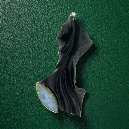 A black chalcedony carving by Steve Walters in an 18kt brooch and pendant with a diamond and Australian opal, made by ART Guyon for Cynthia Scott Jewelry.