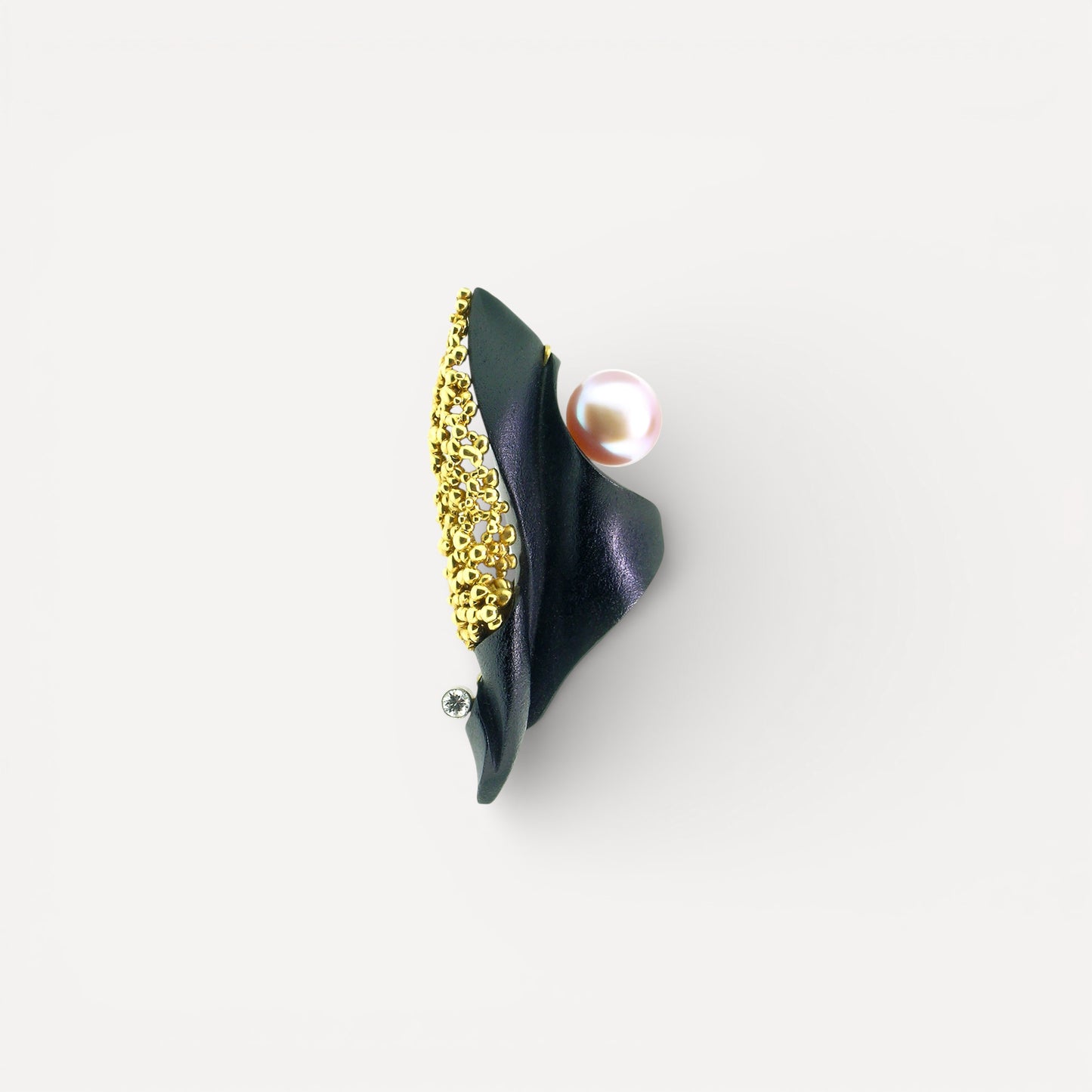 A black chalcedony carving by Steve Walters in an 18kt pendant and brooch with granulation, a diamond, and a pearl by ART Guyon for Cynthia Scott Jewelry.