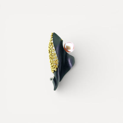 A black chalcedony carving by Steve Walters in an 18kt pendant and brooch with granulation, a diamond, and a pearl by ART Guyon for Cynthia Scott Jewelry.