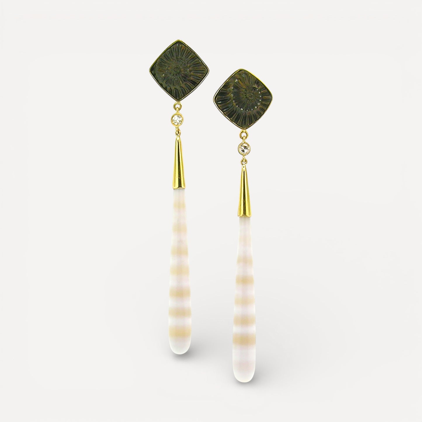 A pair of 18kt gold earrings with pyrite fossil ammonite and German-carved agate which feature alternate bands of creamy white and translucent peach. Made in the USA by Cynthia Scott Jewelry.