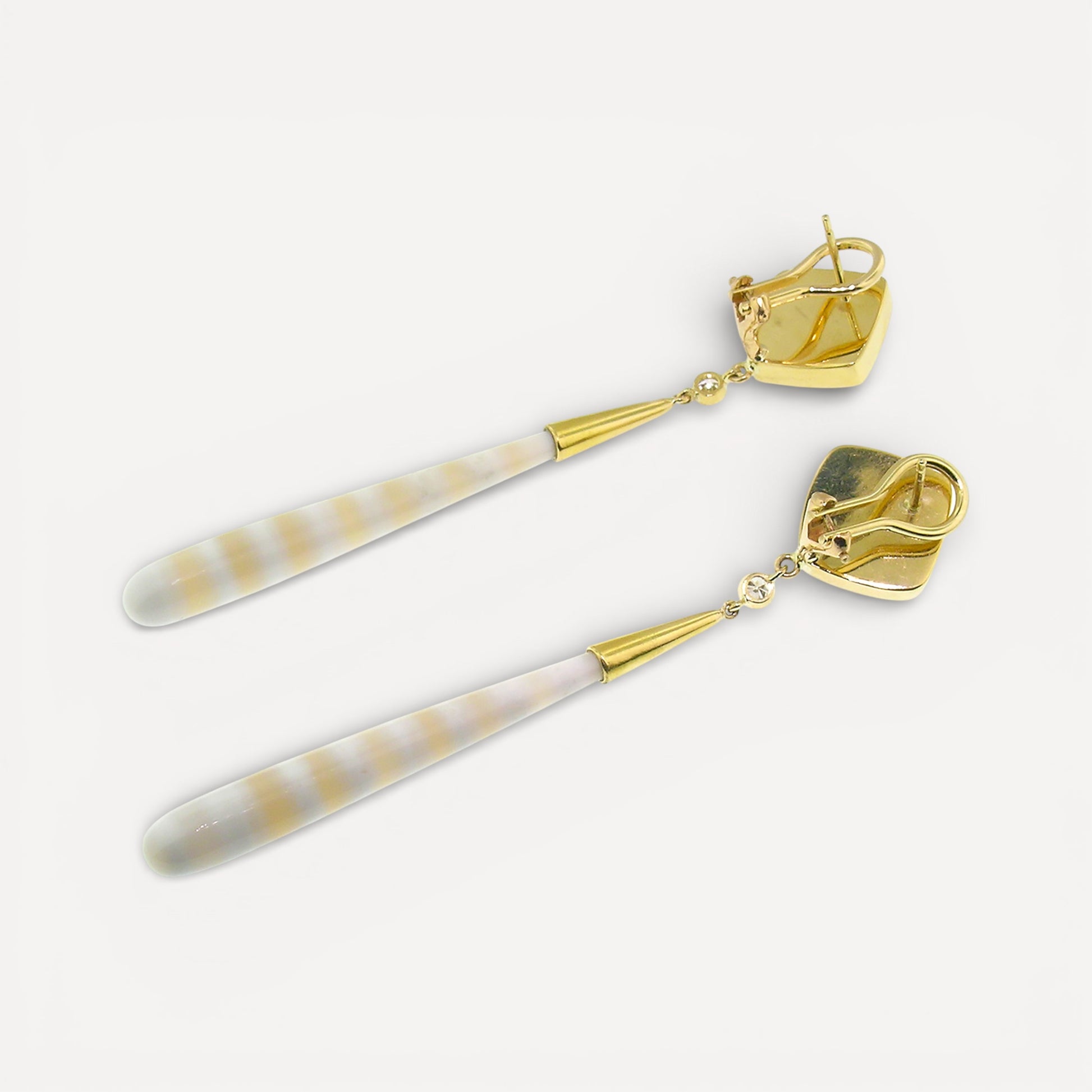 A pair of 18kt gold earrings with pyrite fossil ammonite and German-carved agate which feature alternate bands of creamy white and translucent peach. Made in the USA by Cynthia Scott Jewelry.